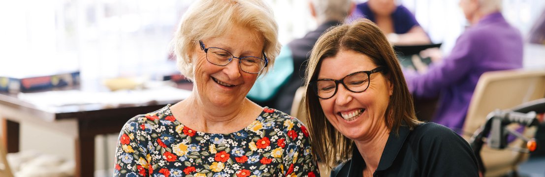 Image of volunteer and a community member playing cards